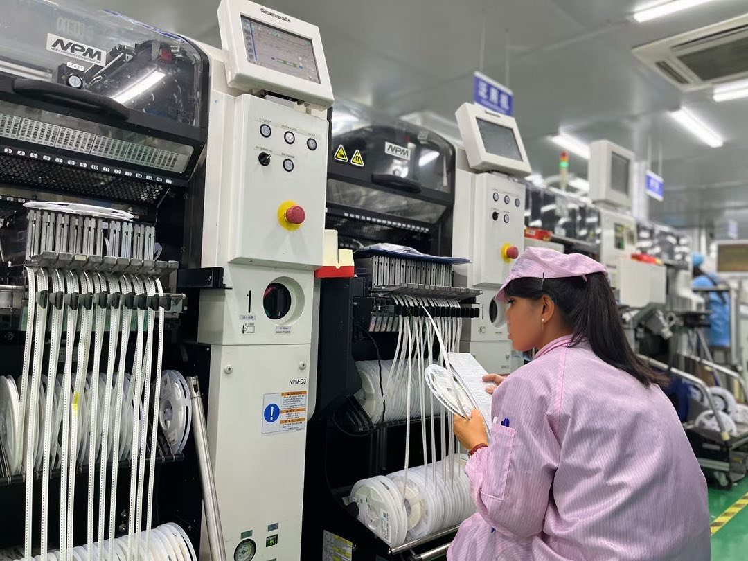 SMT factory production line with operator monitoring pick-and-place equipment